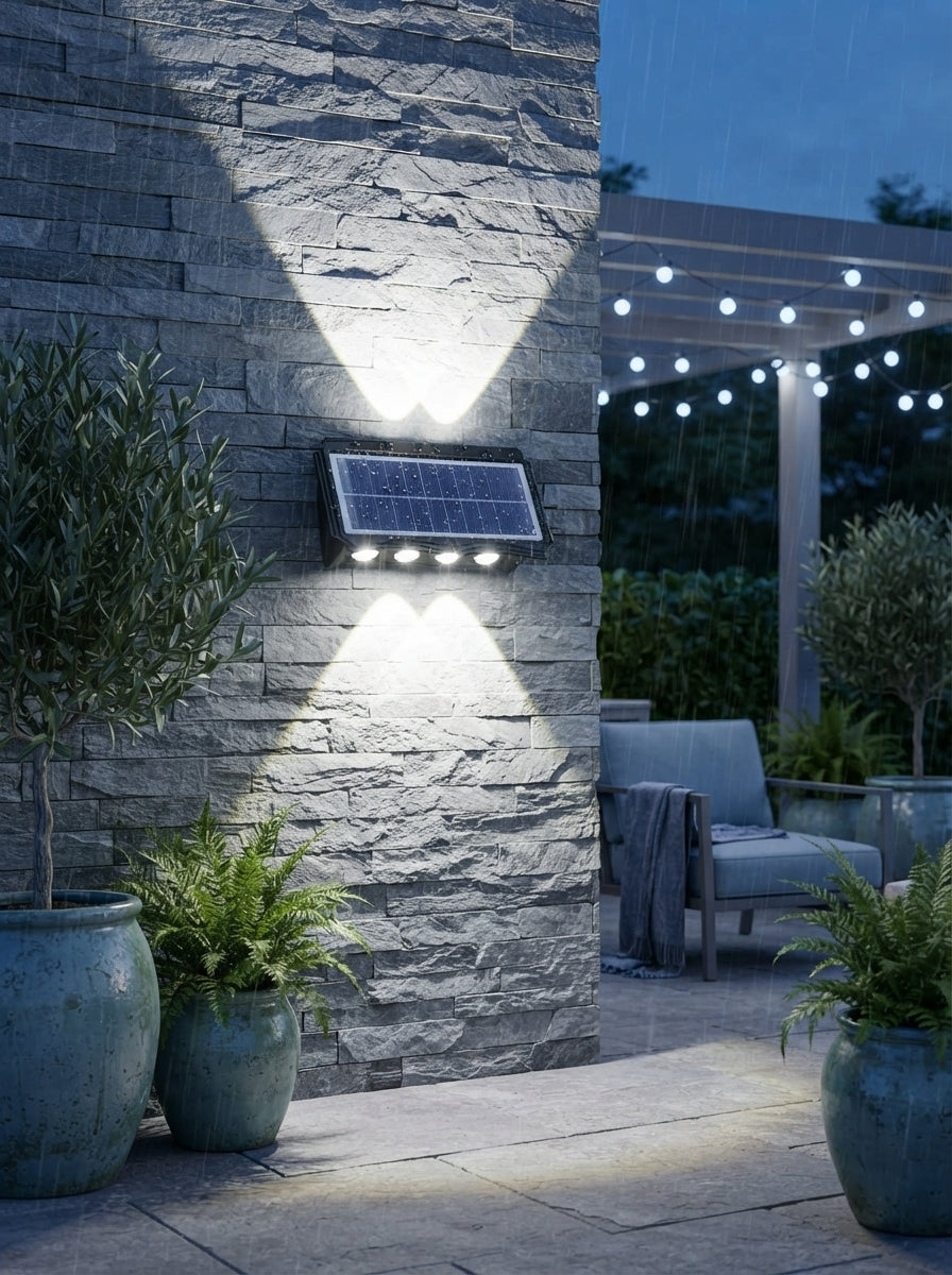 A modern solar up-down wall light mounted on a stone wall, casting bright white light beams upward and downward.